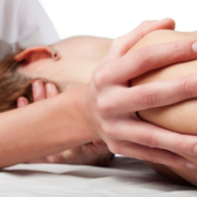 Massage therapist providing massage to shoulder of client